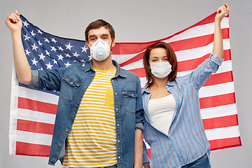 Image showing couple in face masks holding flag of america