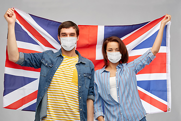 Image showing couple in face masks holding flag of england