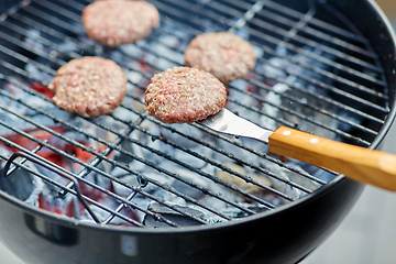 Image showing close up of meat cutlets roasting on grill