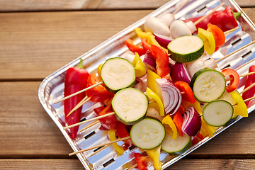 Image showing close up of vegetables on skewers on foil grill