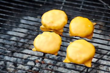 Image showing close up of meat cutlet with cheese on grill