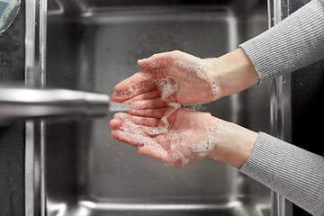 Image showing woman washing hands with soap in kitchen