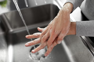 Image showing woman washing hands with soap in kitchen