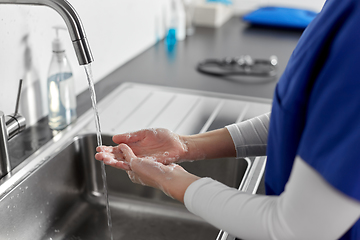 Image showing doctor or nurse washing hands with liquid soap