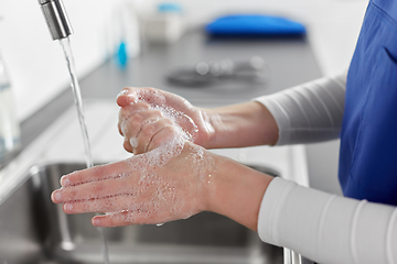 Image showing doctor or nurse washing hands with liquid soap