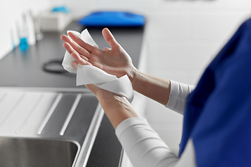 Image showing doctor or nurse drying hands with paper tissue