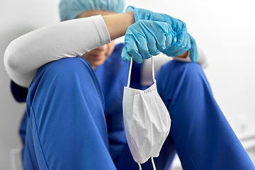 Image showing sad doctor or nurse holding protective face mask