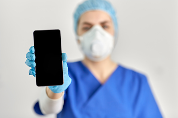 Image showing doctor in goggles and face mask with smartphone