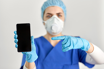 Image showing doctor in goggles and face mask with smartphone