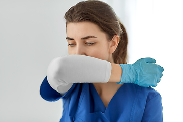 Image showing doctor or nurse coughing covering mouth with elbow