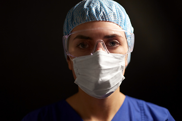 Image showing female doctor or nurse in goggles and face mask