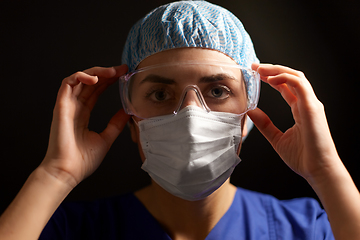 Image showing female doctor or nurse in goggles and face mask