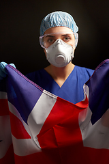 Image showing doctor in goggles and mask holding flag of america
