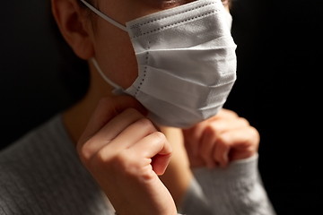 Image showing sick woman adjusting protective medical face mask