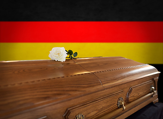 Image showing white rose on wooden coffin over flag of germany