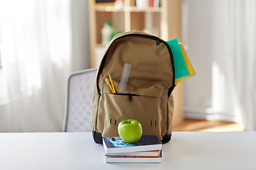 Image showing school backpack with books and apple on table