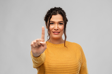 Image showing happy woman in pullover showing one finger