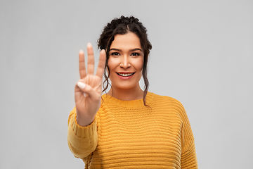 Image showing happy woman in pullover showing three fingers