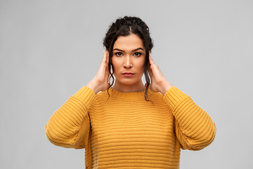 Image showing serious woman closing ears with hands