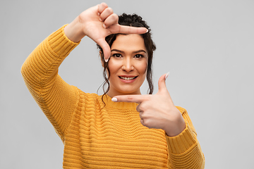 Image showing happy young woman making frame with her fingers