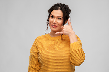 Image showing young woman making phone call gesture