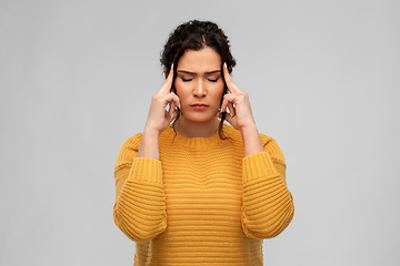 Image showing stressed young woman holding to her head