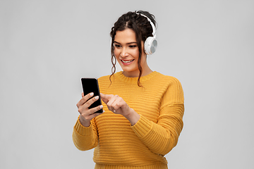 Image showing woman in headphones with smartphone