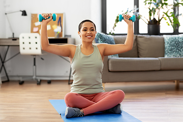 Image showing african woman with dumbbells exercising at home