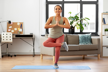 Image showing african american woman doing yoga pose at home