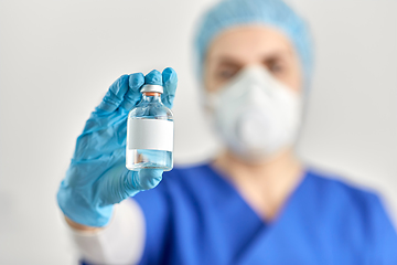 Image showing close up of doctor's hand with bottle of medicine