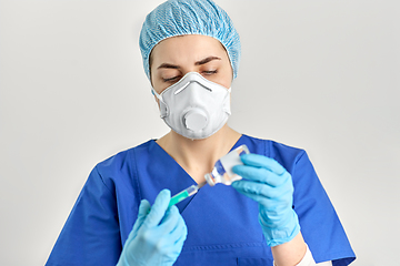 Image showing doctor in face mask with syringe and medicine