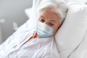 Image showing old woman patient in mask lying in bed at hospital