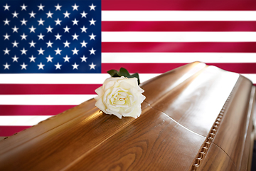 Image showing white rose on wooden coffin over flag of america