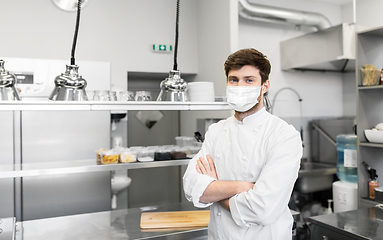 Image showing male chef with in face mask at restaurant kitchen