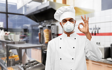 Image showing chef in respirator showing ok sign at kitchen