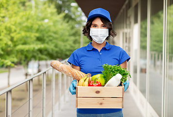 Image showing delivery woman in mask with food in box outdoors