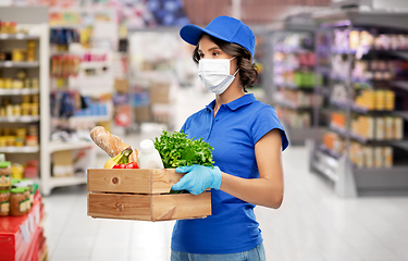 Image showing delivery girl in mask with food in box at store