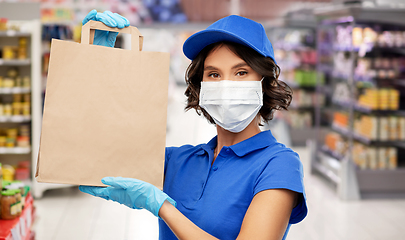 Image showing delivery woman in mask with food in bag at store