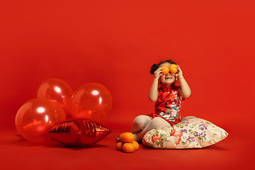 Image showing Happy Chinese New Year. Asian little girl portrait isolated on red background