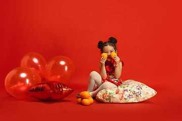 Image showing Happy Chinese New Year. Asian little girl portrait isolated on red background