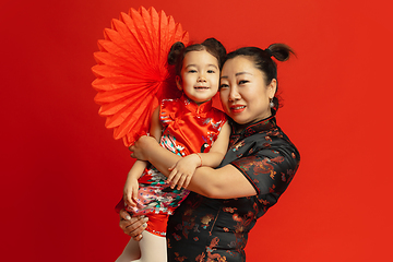 Image showing Happy Chinese New Year. Asian mother and daughter portrait isolated on red background