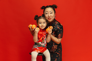 Image showing Happy Chinese New Year. Asian mother and daughter portrait isolated on red background