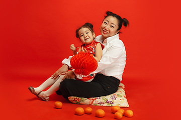 Image showing Happy Chinese New Year. Asian mother and daughter portrait isolated on red background