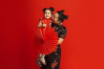 Image showing Happy Chinese New Year. Asian mother and daughter portrait isolated on red background