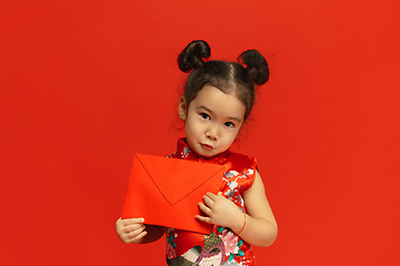 Image showing Happy Chinese New Year. Asian little girl portrait isolated on red background