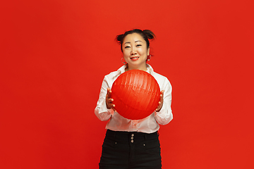 Image showing Happy Chinese New Year. Asian young woman portrait isolated on red background