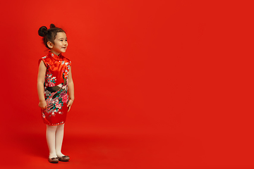 Image showing Happy Chinese New Year. Asian little girl portrait isolated on red background