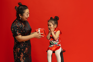 Image showing Happy Chinese New Year. Asian mother and daughter portrait isolated on red background