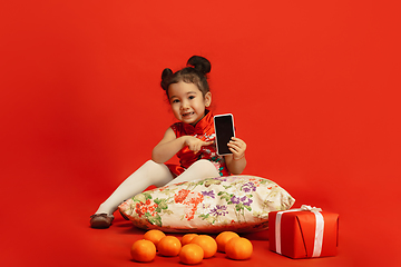 Image showing Happy Chinese New Year. Asian little girl portrait isolated on red background
