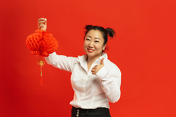 Image showing Happy Chinese New Year. Asian young woman portrait isolated on red background